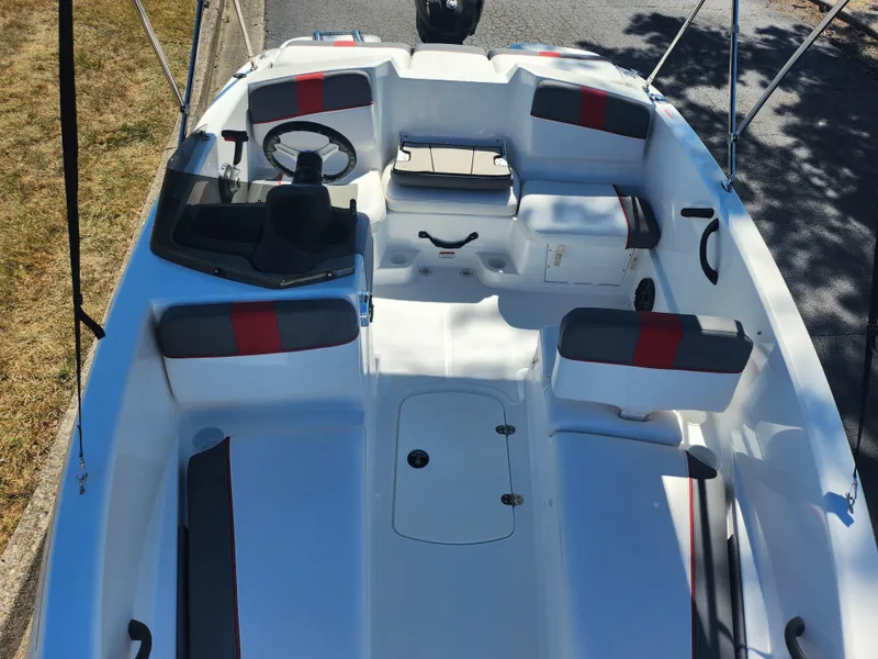 Slide: The Image of 2021 Tahoe T16 boat interior with seating, steering wheel, and storage compartments. - 17