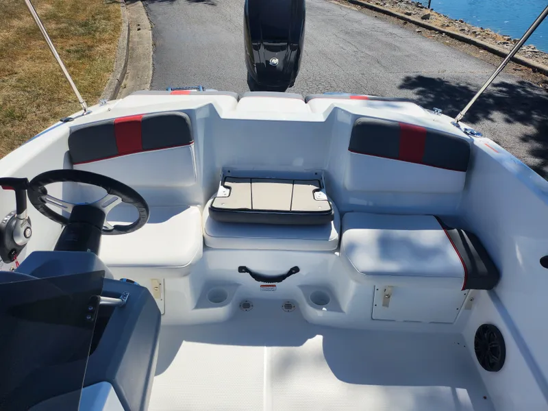 Slide: The Image of 2021 Tahoe T16 boat interior with seating and steering wheel, docked by the water. - 18