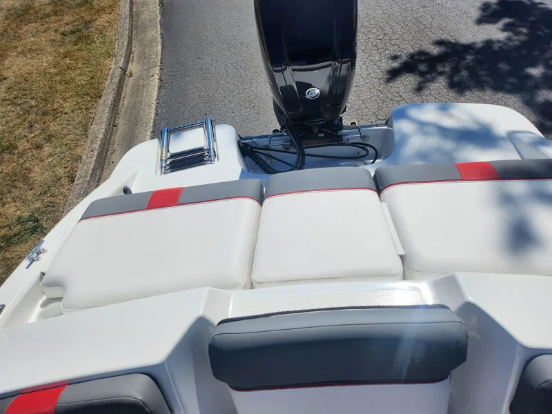 Slide: The Image of 2021 Tahoe T16 boat with white and red seating, parked on a road. - 20