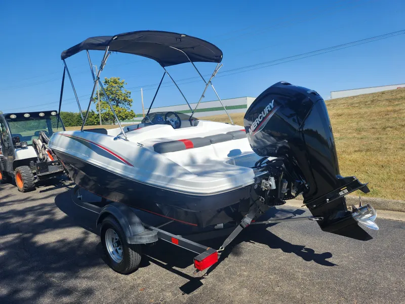 Slide: The Image of 2021 Tahoe T16 boat with Mercury outboard engine on trailer, parked outdoors. - 3