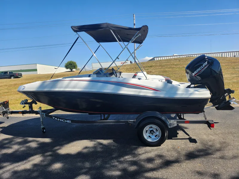 Slide: The Image of 2021 Tahoe T16 boat with canopy on trailer, parked outdoors under clear sky. - 4