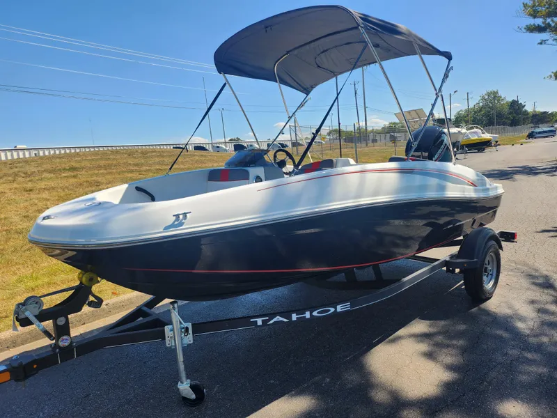 Slide: The Image of 2021 Tahoe T16 boat on trailer with canopy, parked on roadside under clear blue sky. - 5