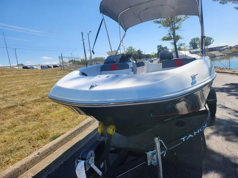 Slide: The Image of 2021 Tahoe T16 boat on trailer, parked near a lake under clear skies. - 6