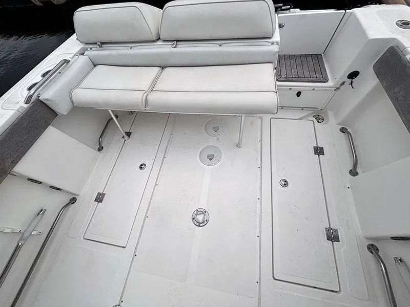 Slide: The Image of 2003 Marlago FS35 boat interior with white seating and storage compartments. - 11