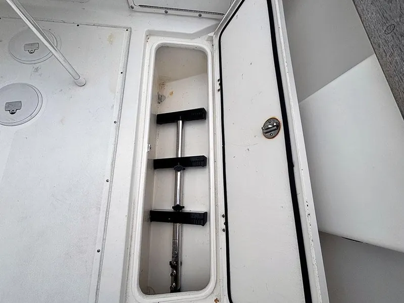 Slide: The Image of Storage compartment in a 2003 Marlago FS35 boat, featuring a secure latch and organized interior. - 12