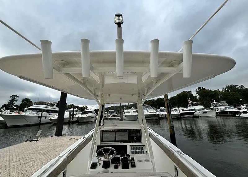 Slide: The Image of 2003 Marlago FS35 boat at marina, featuring helm and overhead rod holders. - 14