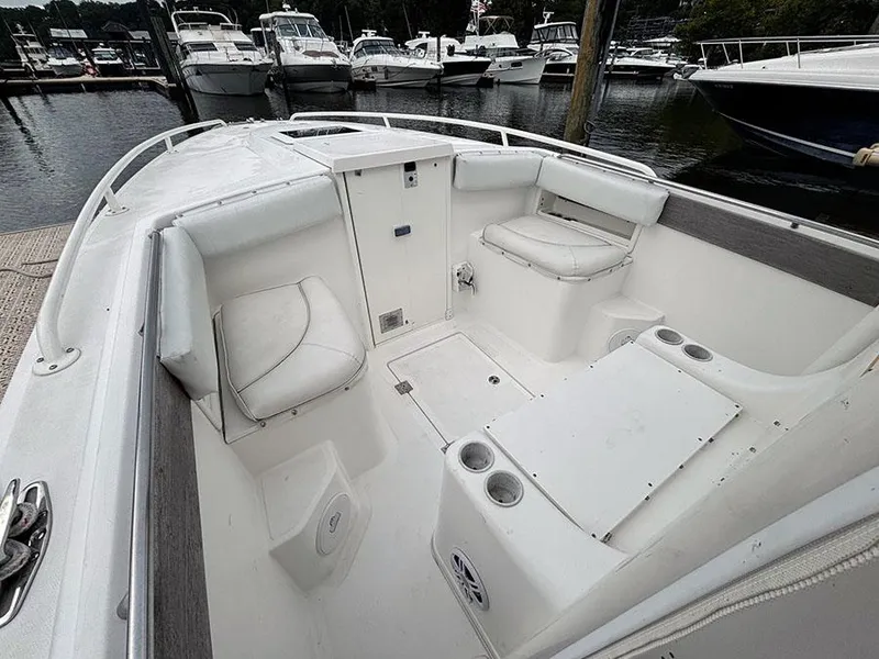 Slide: The Image of 2003 Marlago FS35 boat interior with white seating and cup holders at a marina. - 28