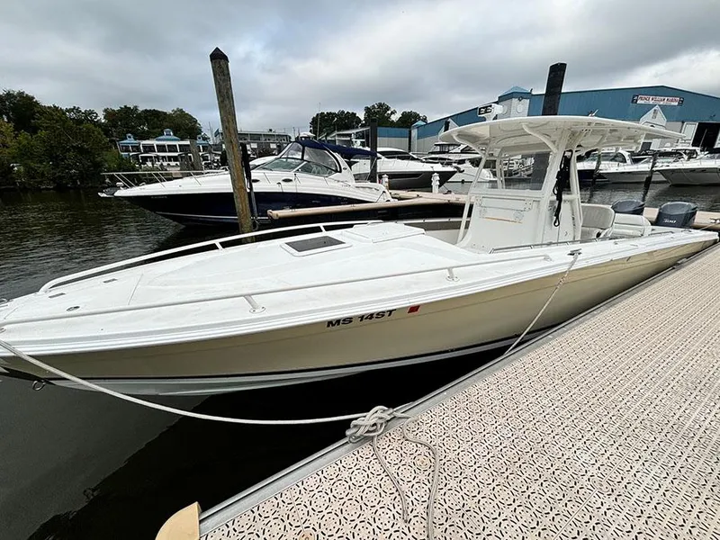 Slide: The Image of 2003 Marlago FS35 boat docked at marina, overcast sky, surrounded by other boats. - 5