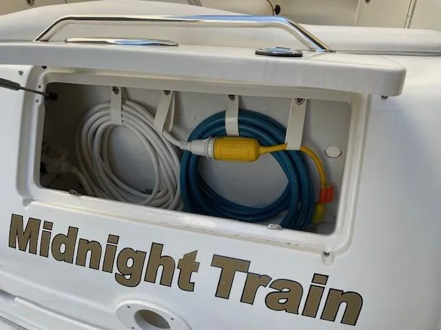Slide: The Image of Sea Ray 280 Sundancer 2001 boat storage compartment with cables, labeled "Midnight Train." - 14