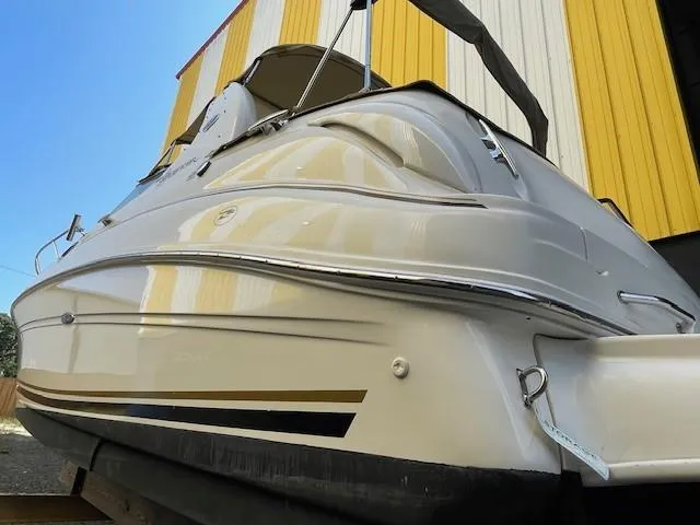 Slide: The Image of 2001 Sea Ray 280 Sundancer boat, docked near a yellow and white building. - 2