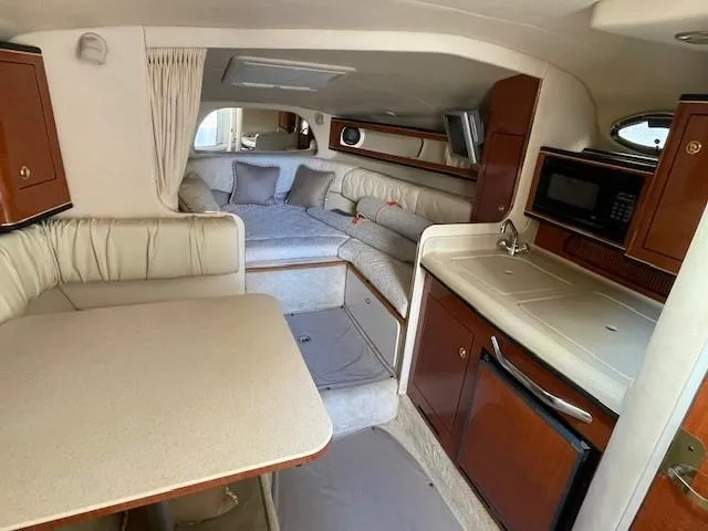 Slide: The Image of Interior of 2001 Sea Ray 280 Sundancer with kitchenette, seating, and sleeping area. - 24