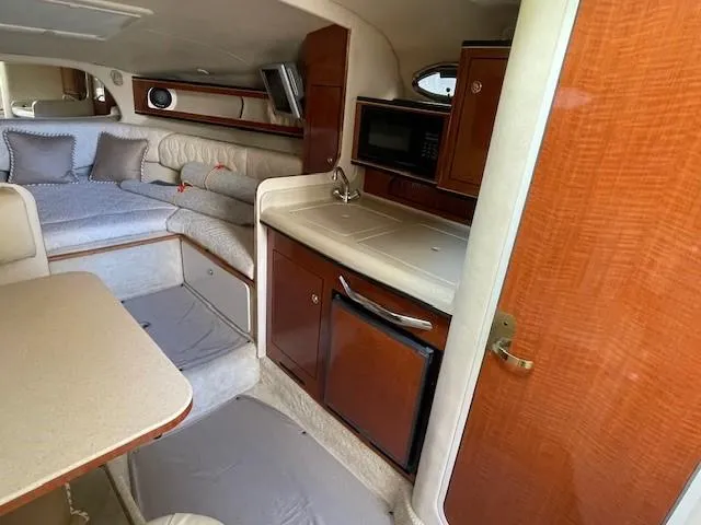 Slide: The Image of Interior of 2001 Sea Ray 280 Sundancer boat with kitchenette and seating area. - 26