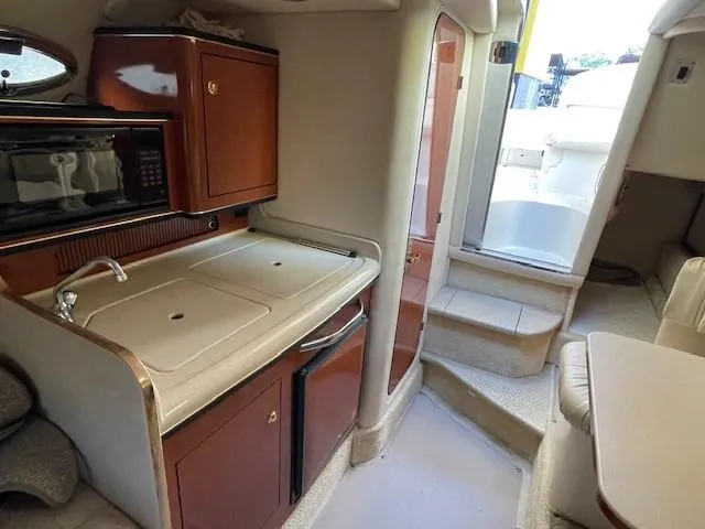Slide: The Image of 2001 Sea Ray 280 Sundancer interior with kitchenette and seating area. - 27