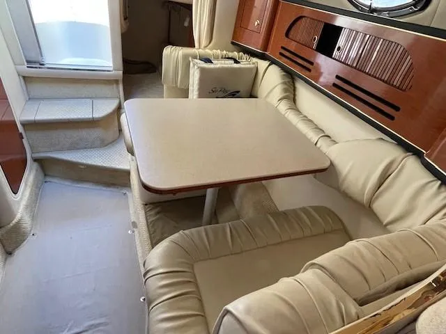 Slide: The Image of 2001 Sea Ray 280 Sundancer interior with beige seating and dining table. - 28
