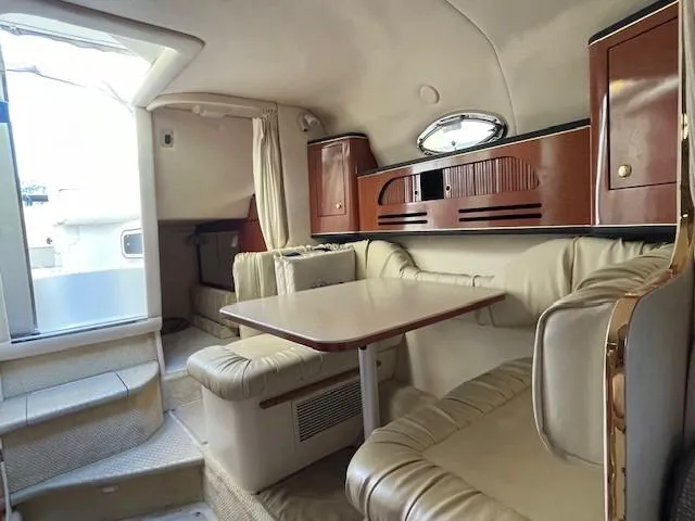 Slide: The Image of Interior of 2001 Sea Ray 280 Sundancer with beige seating and wooden cabinetry. - 31
