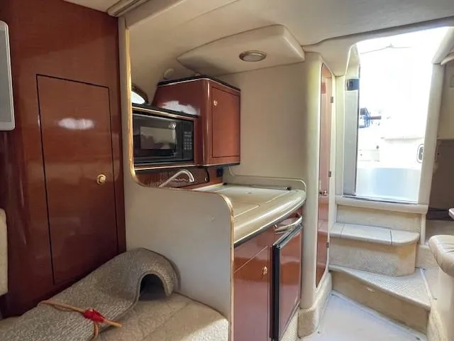 Slide: The Image of Interior of 2001 Sea Ray 280 Sundancer with kitchenette and seating area. - 32