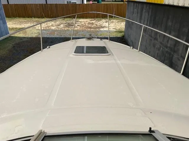 Slide: The Image of 2001 Sea Ray 280 Sundancer boat deck, white surface, metal railings, outdoor setting. - 34