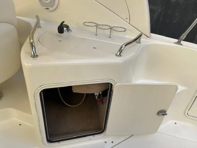 Slide: The Image of 2001 Sea Ray 280 Sundancer boat interior with open storage compartment and cup holders. - 35