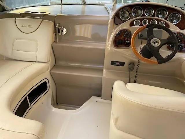 Slide: The Image of Interior of 2001 Sea Ray 280 Sundancer boat with beige seating and dashboard. - 8