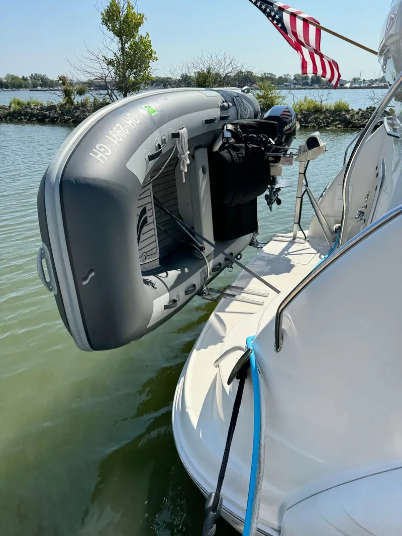 Slide: The Image of 2005 Sea Ray 390 Motor Yacht with inflatable dinghy and American flag on water. - 10