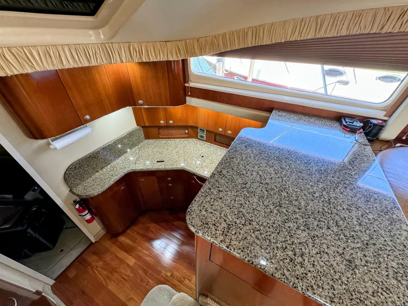 Slide: The Image of Luxurious 2005 Sea Ray 390 Motor Yacht interior with granite countertops and wood cabinetry. - 31