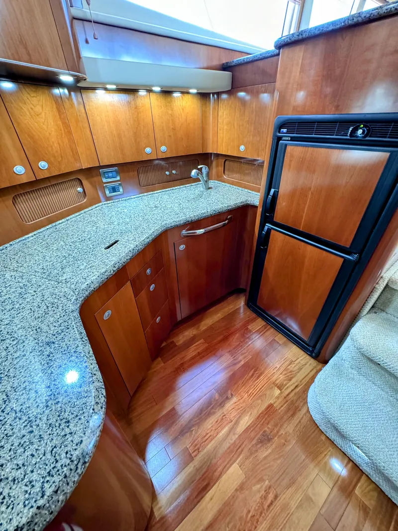 Slide: The Image of Luxurious 2005 Sea Ray 390 Motor Yacht kitchen with wood cabinetry and granite countertops. - 32