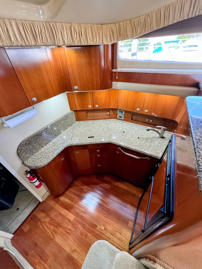 Slide: The Image of Luxurious 2005 Sea Ray 390 Motor Yacht kitchen with wood cabinetry and granite countertops. - 33