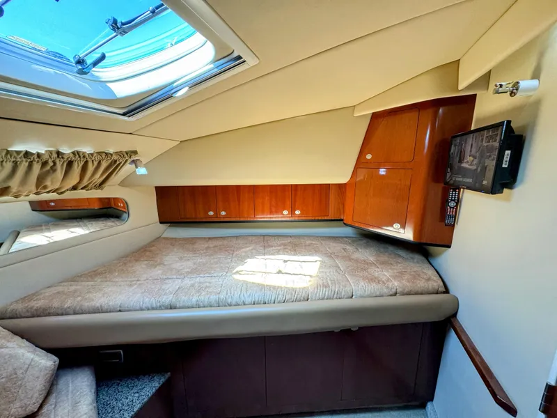 Slide: The Image of 2005 Sea Ray 390 Motor Yacht interior cabin with bed, skylight, and wooden cabinets. - 49