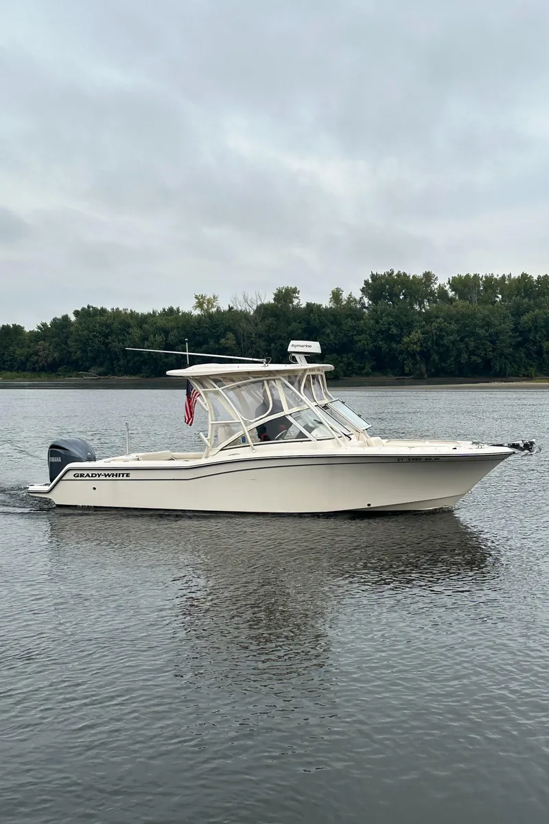 Slide: The Image of 2022 Grady-White Freedom 235 boat on calm water, overcast sky, side view. - 1