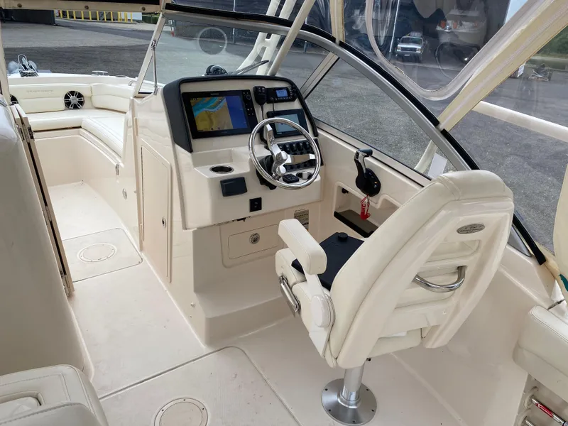 Slide: The Image of 2022 Grady-White Freedom 235 boat interior with helm, steering wheel, and navigation display. - 10