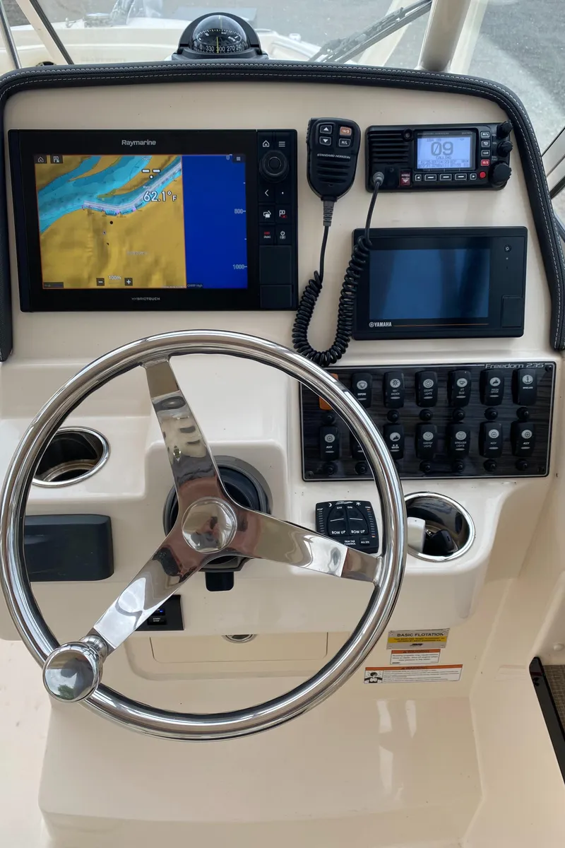 Slide: The Image of 2022 Grady-White Freedom 235 boat dashboard with navigation system and controls. - 12
