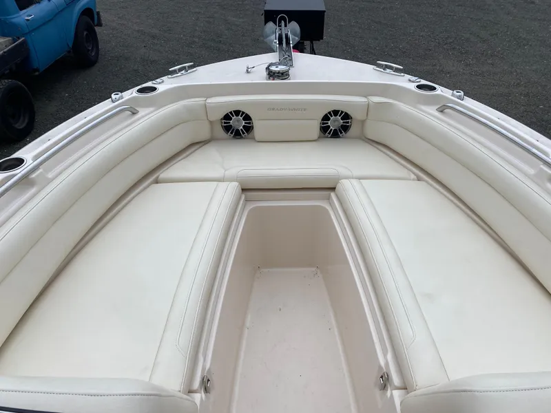 Slide: The Image of 2022 Grady-White Freedom 235 boat interior with white cushioned seating and cup holders. - 14