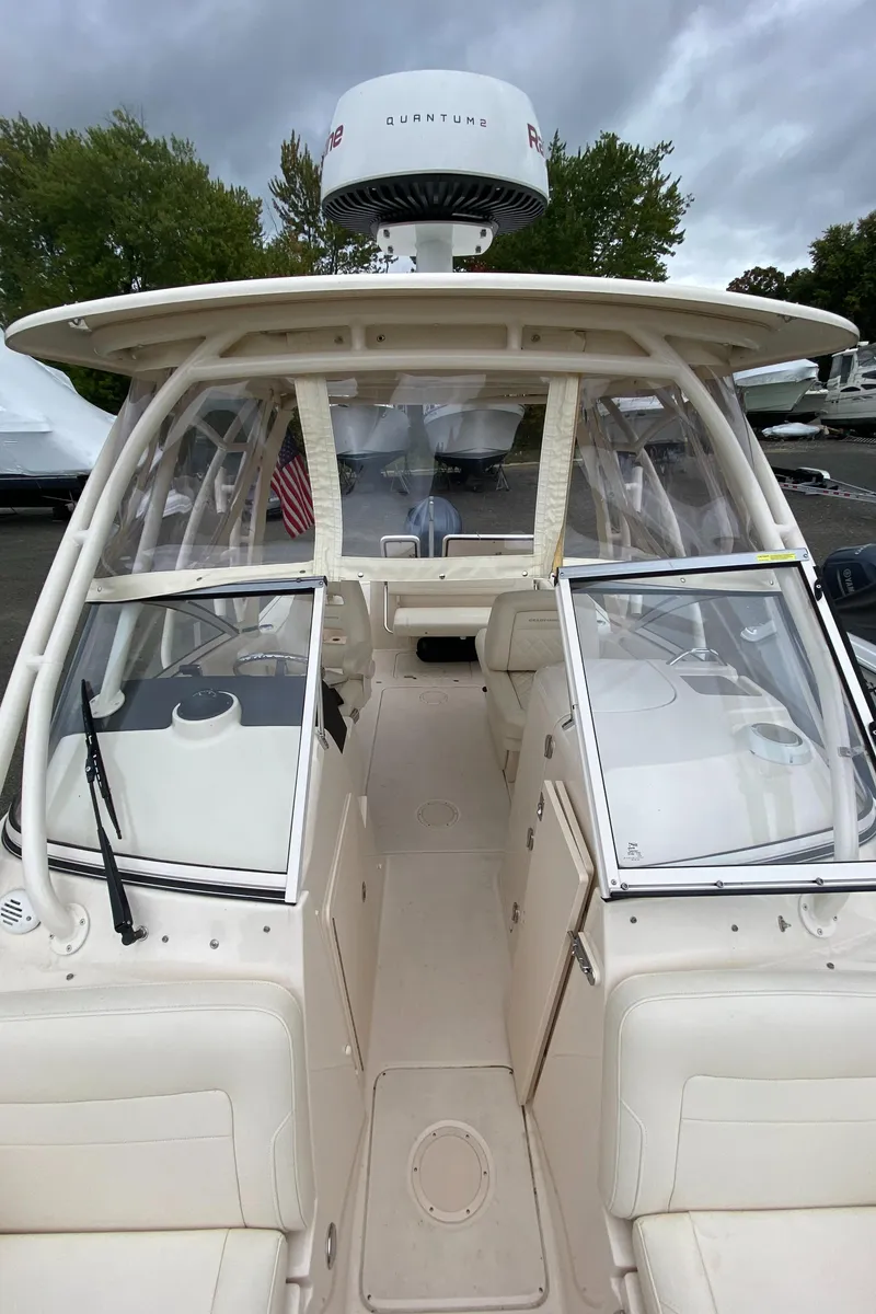 Slide: The Image of 2022 Grady-White Freedom 235 boat interior with open cockpit and windshield, under cloudy sky. - 16