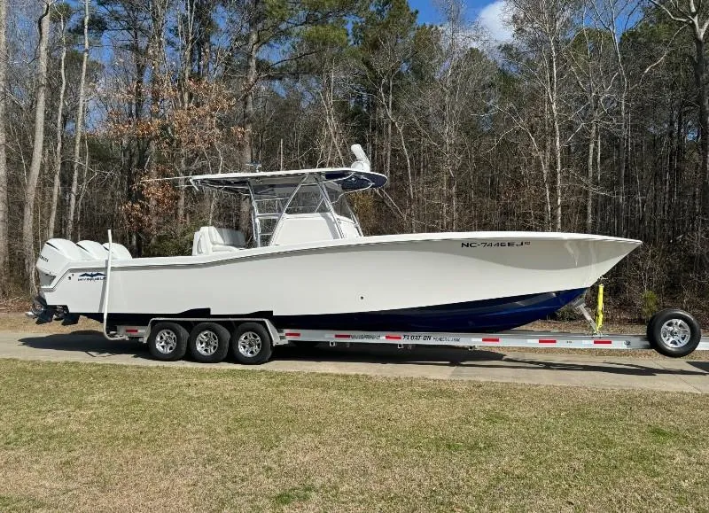 The Image of 2019 Invincible 36 Open Fisherman boat on trailer in wooded area. - 0