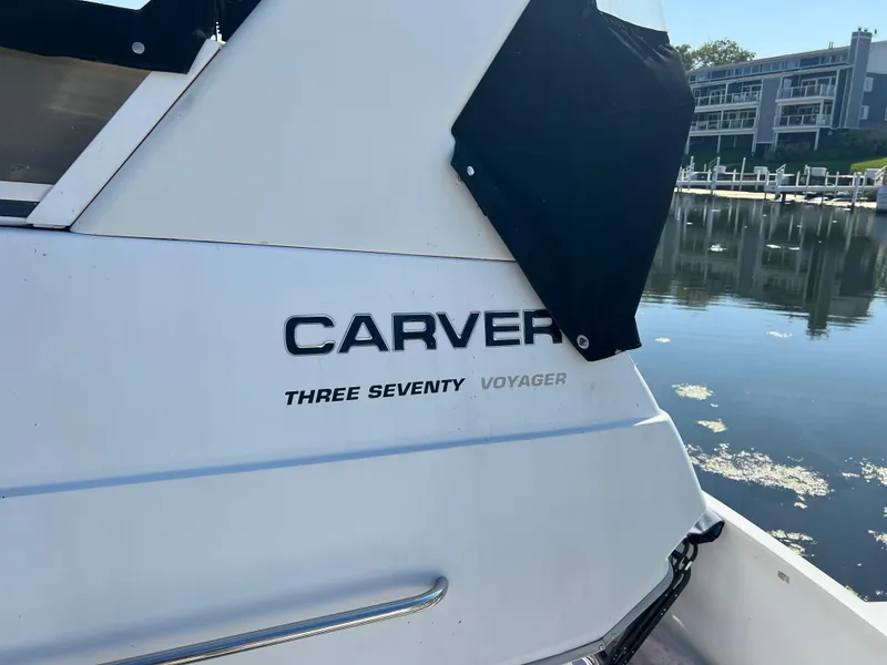 Slide: The Image of 1999 Carver 370 Voyager boat docked by waterfront buildings. - 28