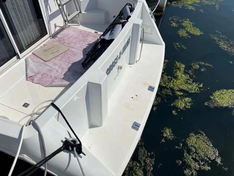 Slide: The Image of 1999 Carver 370 Voyager yacht docked, showing rear deck and water with algae. - 29