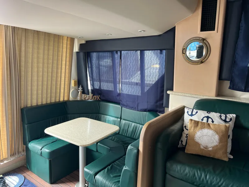 Slide: The Image of Interior of 1999 Carver 370 Voyager yacht with green seating and nautical decor. - 13