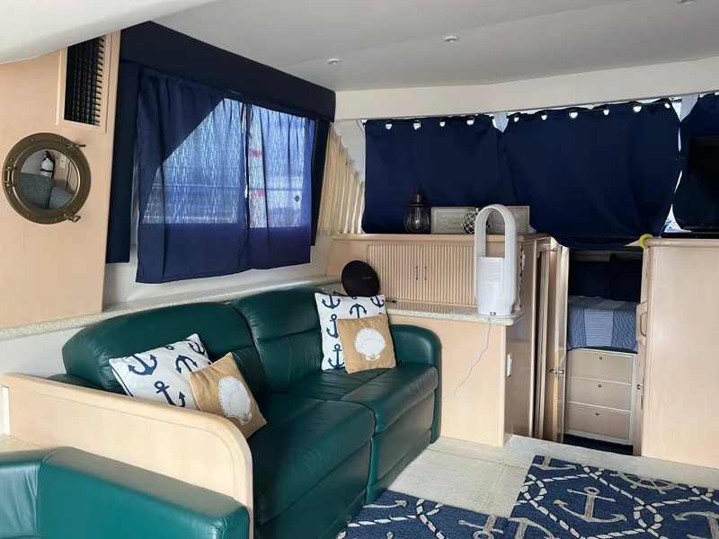 Slide: The Image of Interior of 1999 Carver 370 Voyager yacht with green leather sofa and nautical decor. - 14