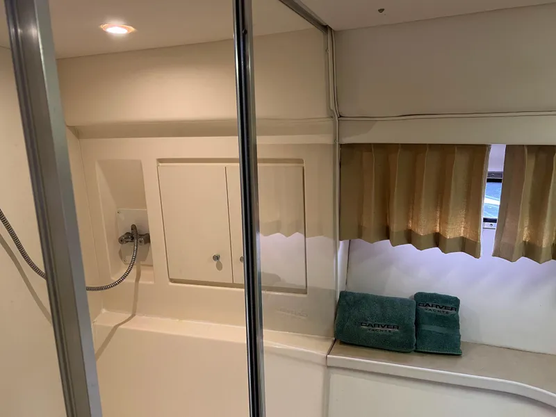 Slide: The Image of 1999 Carver 370 Voyager bathroom with shower, towels, and window curtain. - 18