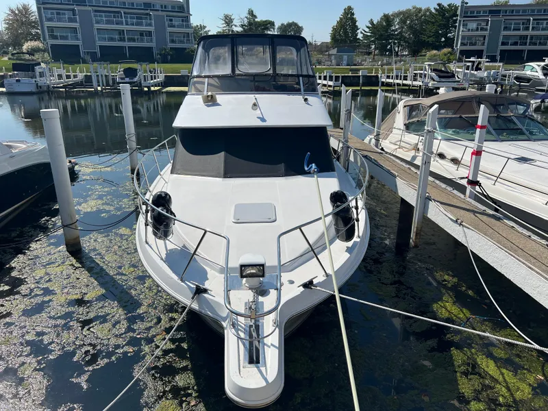 Slide: The Image of 1999 Carver 370 Voyager docked in a marina, surrounded by other boats. - 2