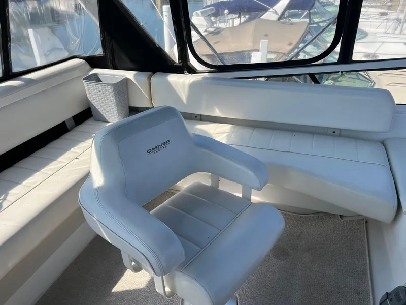 Slide: The Image of 1999 Carver 370 Voyager interior with white seating and helm chair. - 6