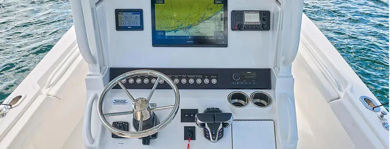 Slide: The Image of 2026 Regulator 23 boat dashboard with navigation screens and steering wheel on open water. - 9