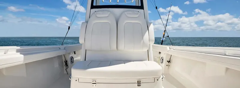 Slide: The Image of 2026 Regulator 23 boat interior with white seating, ocean view, and fishing rods. - 6