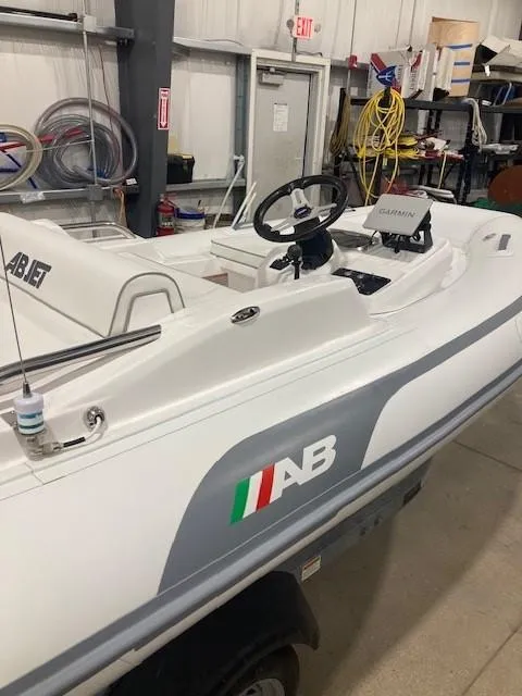 Slide: The Image of 2023 AB Inflatables ABJET 350XP boat in a workshop setting. - 2