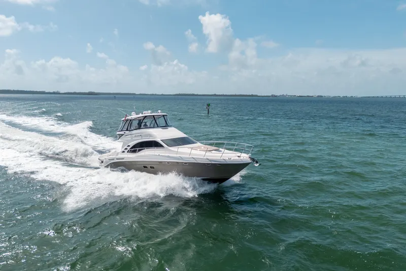 Slide: The Image of 2006 Sea Ray 58 Sedan Bridge cruising on open water under a clear blue sky. - 14