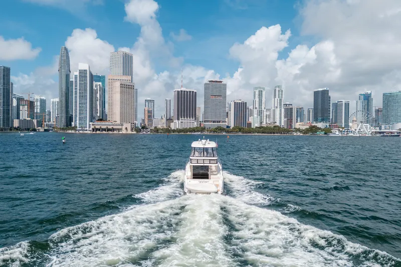 Slide: The Image of Sea Ray 58 Sedan Bridge yacht cruising near city skyline, 2006 model. - 15