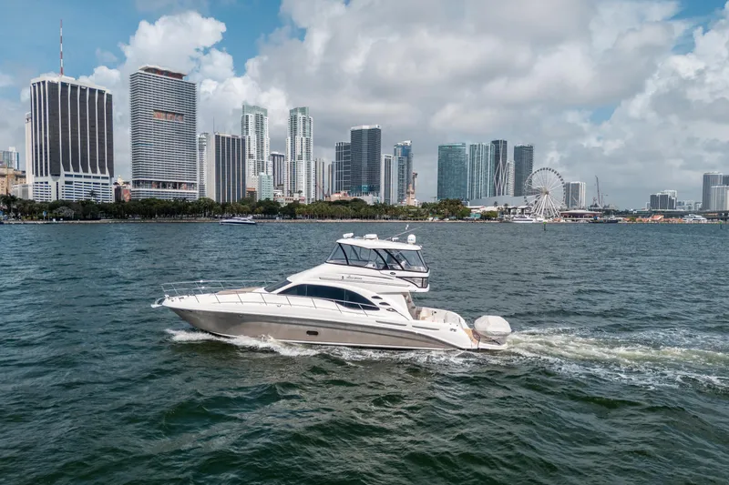 Slide: The Image of 2006 Sea Ray 58 Sedan Bridge yacht cruising near city skyline. - 16