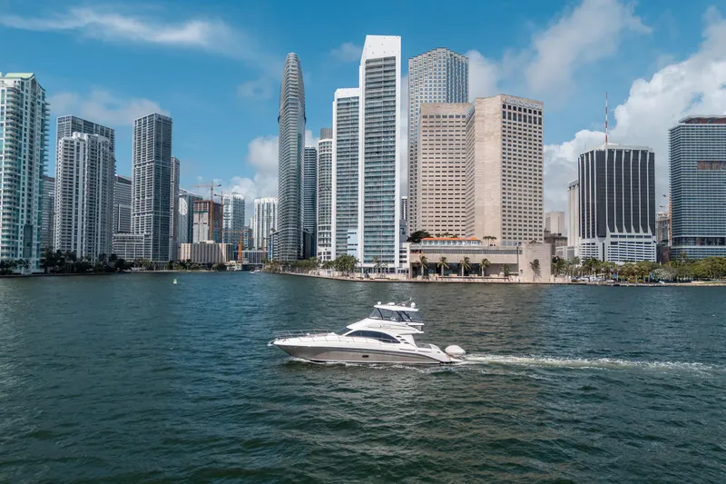 Slide: The Image of 2006 Sea Ray 58 Sedan Bridge yacht cruising near city skyline. - 17