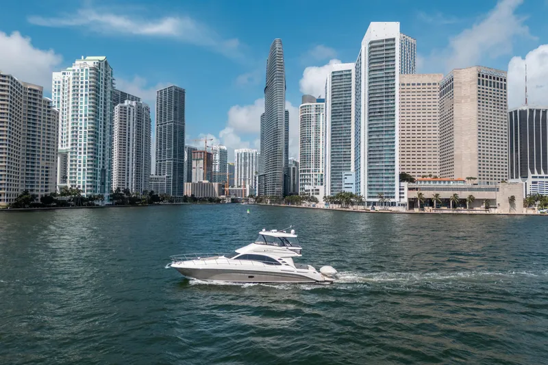 Slide: The Image of Sea Ray 58 Sedan Bridge yacht cruising near city skyline, 2006 model. - 18