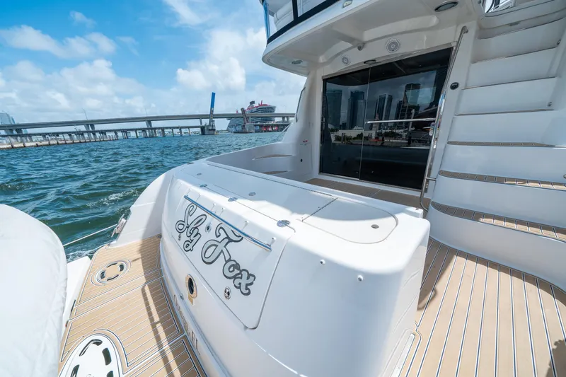 Slide: The Image of 2006 Sea Ray 58 Sedan Bridge yacht on water, featuring spacious deck and city skyline. - 24